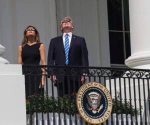 El presidente de los Estados Unidos, Donald Trump, busca el eclipse solar parcial con la Primera Dama Melania Trump desde el balcón de la Casa Blanca en Washington, DC, el 21 de agosto de 2017. Foto: Afp
