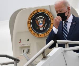 El presidente de Estados Unidos, Joe Biden, se toca la mascarilla al bajar del Air Force One a su llegada al aeropuerto regional de Hagerstown, Maryland.