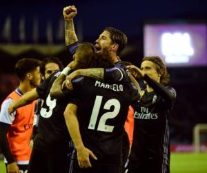 Real Madrid's French forward Karim Benzema (L) celebrates with Real Madrid's defender Sergio Ramos (backC) after scoring their third goal during the Spanish league football match RC Celta de Vigo vs Real Madrid CF at the Balaidos stadium in Vigo on May 17, 2017. / AFP PHOTO / MIGUEL RIOPA