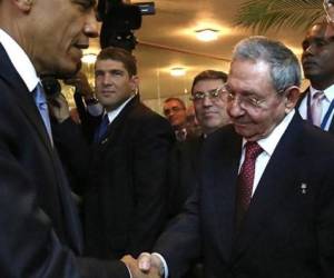 Barack Obama y el mandatario cubano Raúl Castro se estrechan la mano.