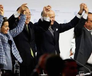 El presidente francés Francois Hollande, el secretario general de la ONU, Ban Ki-moon, y el canciller francés, Laurent Fabius, celebran la aprobación del acuerdo de cambio climático del COP21. | AFP