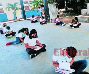 Los alumnos permanecen sentados en el piso cuando reciben clases en el gimnasio.