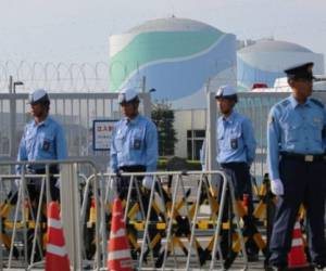 Oficiales de la policía custodian la entrada de la planta nuclear en Sendai.