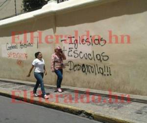 Las paredes del exterior de la catedral Metropolitana quedaron manchadas con mensajes negativos y de odio hechos por personas que se cubren sus rostros, fotos: El Heraldo.