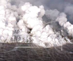 Esta imagen tomada de un video el lunes 4 de junio de 2018 y proporcionada por el Servicio Geológico de Estados Unidos muestra lava que ingresa al océano en la Bahía de Kapoho en Hawái.