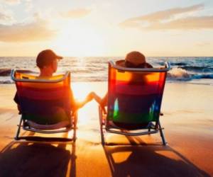 Imagen de dos personas disfrutando de un hermoso atardecer en la playa.