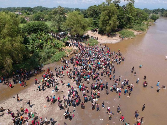 FOTOS: Con cadena humana migrantes intentan cruzar el río Suchiate que divide Guatemala y México