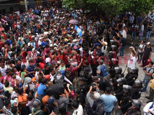 FOTOS: Así fue el momento en el que la caravana migrante de hondureños rompió los portones e ingresó a México