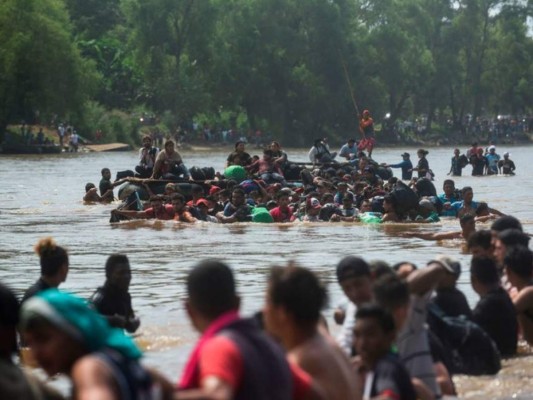 FOTOS: Con cadena humana migrantes intentan cruzar el río Suchiate que divide Guatemala y México