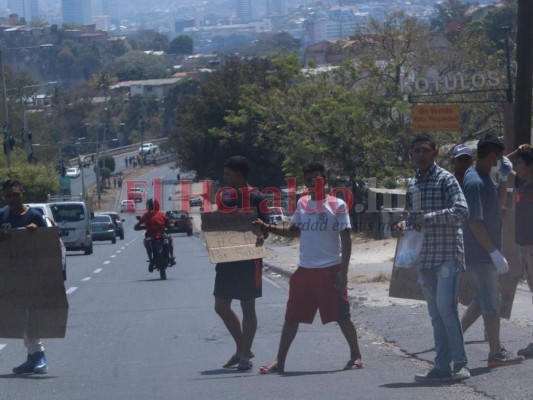 Con latas y rótulos de 'tengo hambre' pobladores piden ayuda en bulevar FFAA