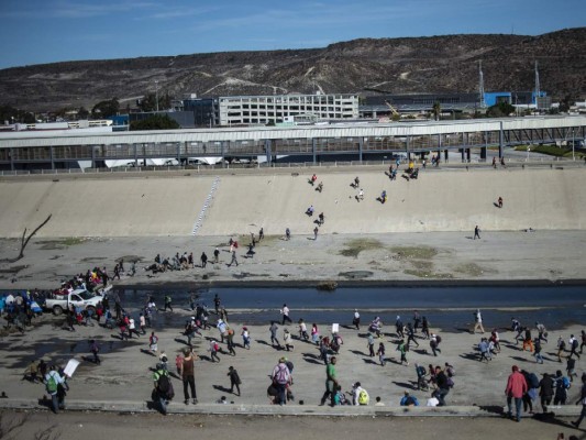 Fotos del momento en el que migrantes de la caravana saltaron valla fronteriza de Estados Unidos, pero fueron detenidos con gases lacrimógenos