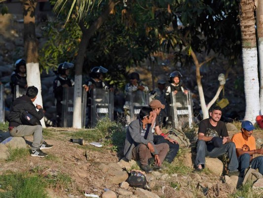 Entre basura y secando ropa en piedras, migrantes siguen varados en río Suchiate