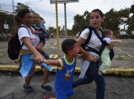 FOTOS: Así fue el momento en el que la caravana migrante de hondureños rompió los portones e ingresó a México