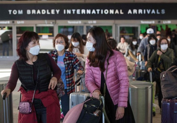 FOTOS: Con trajes de protección reciben a personas evacuadas de China