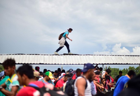 FOTOS: Así fue el momento en el que la caravana migrante de hondureños rompió los portones e ingresó a México