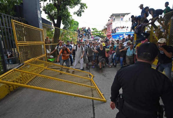 FOTOS: Así fue el momento en el que la caravana migrante de hondureños rompió los portones e ingresó a México