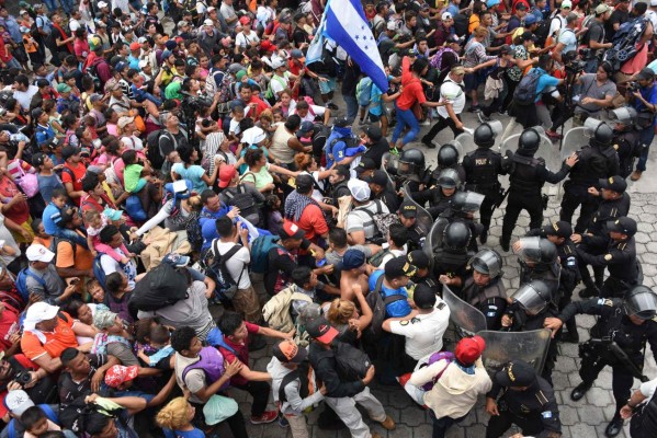 FOTOS: Así fue el momento en el que la caravana migrante de hondureños rompió los portones e ingresó a México