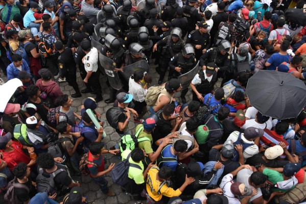 FOTOS: Así fue el momento en el que la caravana migrante de hondureños rompió los portones e ingresó a México