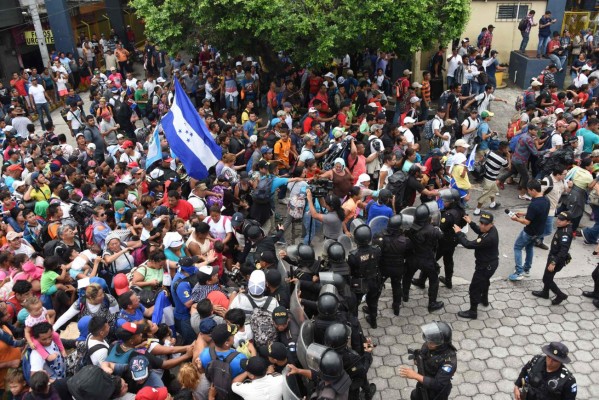 FOTOS: Así fue el momento en el que la caravana migrante de hondureños rompió los portones e ingresó a México