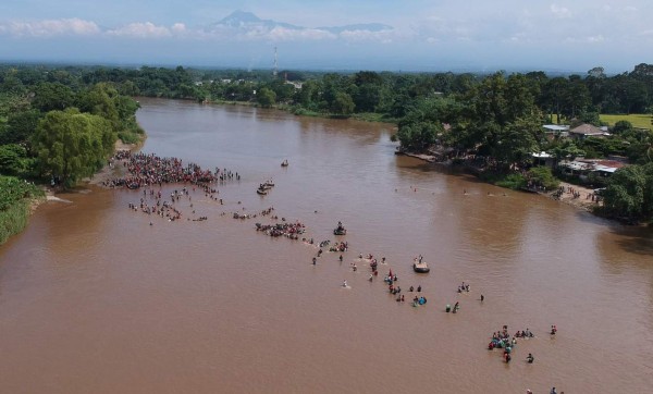 FOTOS: Con cadena humana migrantes intentan cruzar el río Suchiate que divide Guatemala y México