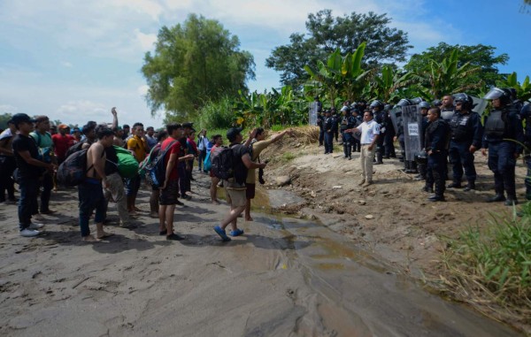 FOTOS: Con cadena humana migrantes intentan cruzar el río Suchiate que divide Guatemala y México