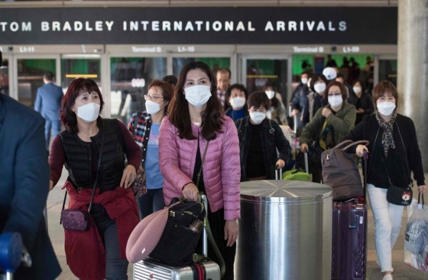 FOTOS: Con trajes de protección reciben a personas evacuadas de China