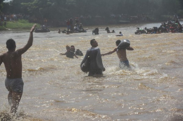 FOTOS: Con cadena humana migrantes intentan cruzar el río Suchiate que divide Guatemala y México