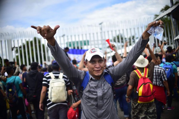 FOTOS: Así fue el momento en el que la caravana migrante de hondureños rompió los portones e ingresó a México