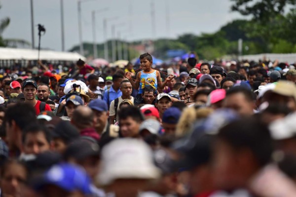 FOTOS: Así fue el momento en el que la caravana migrante de hondureños rompió los portones e ingresó a México