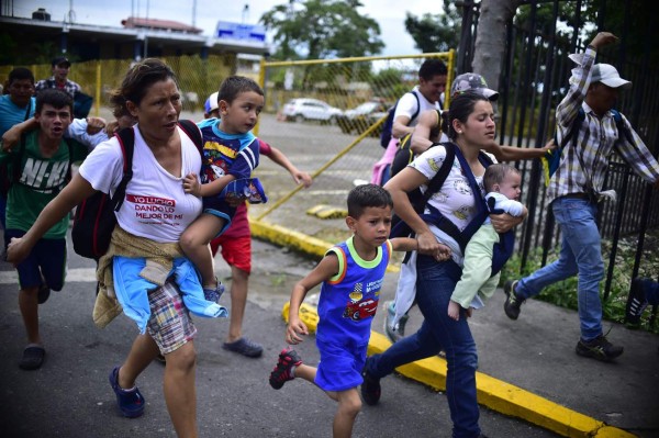 FOTOS: Así fue el momento en el que la caravana migrante de hondureños rompió los portones e ingresó a México