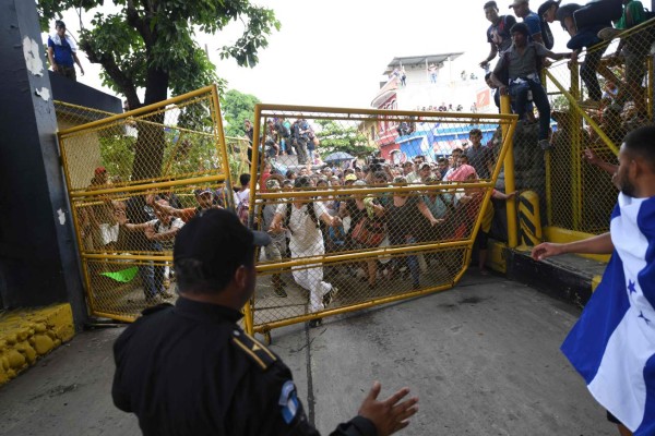 FOTOS: Así fue el momento en el que la caravana migrante de hondureños rompió los portones e ingresó a México