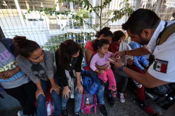 FOTOS: Con brazaletes en sus manos identifican a mujeres, hombres y niños de la caravana migrante en México