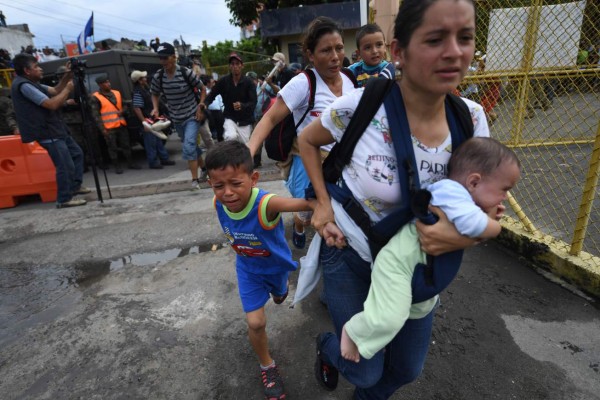 FOTOS: Así fue el momento en el que la caravana migrante de hondureños rompió los portones e ingresó a México