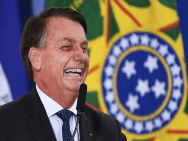 El presidente brasileño Jair Bolsonaro se ríe durante la ceremonia de inauguración de su nuevo ministro de Turismo, Gilson Machado. Foto: Agencia AFP.