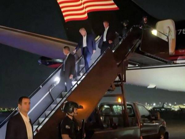 Momento en que el expresidente de Estados Unidos, Donald Trump, desciende de su avión privado, escoltado y con un aparente buen estado de salud y ánimo.