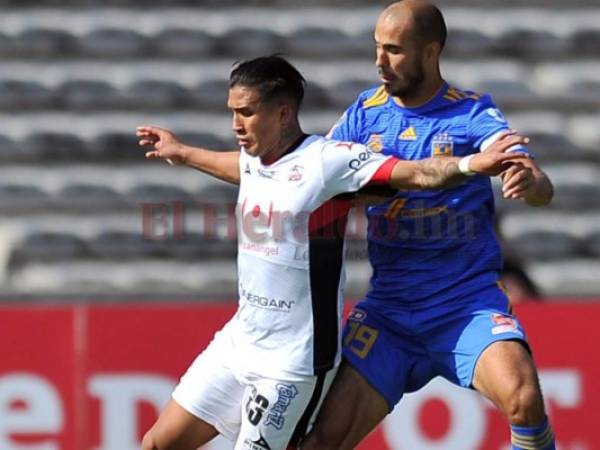 Michaell Chirinos ante el argentino Guido Pizarro en el duelo Lobos BUAP vs Tigres. (AFP)