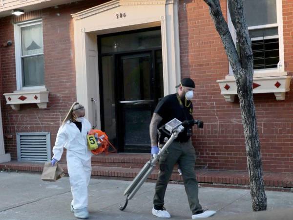 Los forenses saliendo de la vivienda donde estaban los cuerpos.