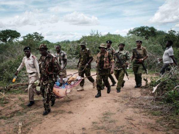 Personal de seguridad lleva a un joven rescatado del bosque en Shakahola, en las afueras de la ciudad costera de Malindi.