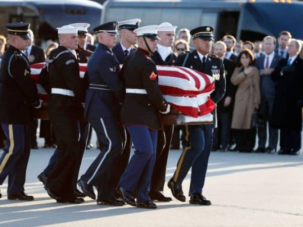 Los miembros de la familia ven cómo el ataúd cubierto con la bandera del expresidente de los Estados Unidos, George H.W. Bush, es transportado por una guardia de honor militar de servicios conjuntos durante una ceremonia de llegada el lunes 3 de diciembre de 2018 en la Base de la Fuerza Aérea Andrews en Maryland. (Foto: AFP)