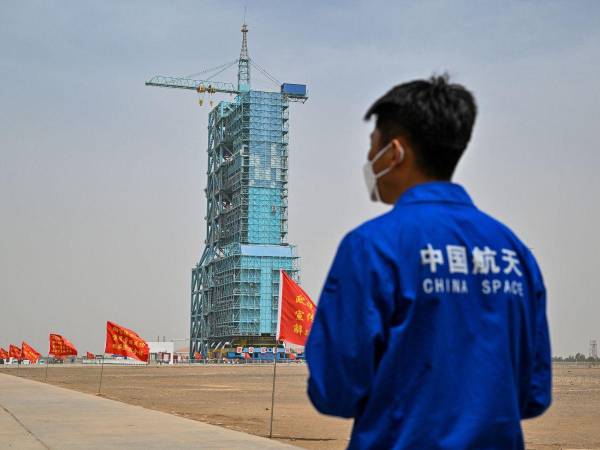 Un miembro del personal del programa espacial de China se encuentra ante la plataforma de lanzamiento de la Misión de Vuelo Espacial Tripulado Shenzhou-16 un día antes del lanzamiento en el Centro de Lanzamiento de Satélites de Jiuquan en la provincia noroccidental china de Gansu el 29 de mayo de 2023.