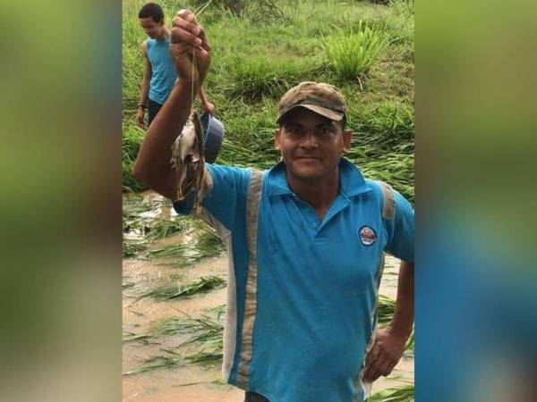 Un yoreño sostiene en su mano un grupo de peces que habría recogido tras la lluvia.