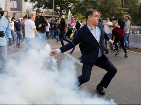 Un oponente del presidente de Venezuela, Nicolás Maduro, devuelve un recipiente de gas lacrimógeno en Caracas, Venezuela, el lunes 29 de abril de 2019.