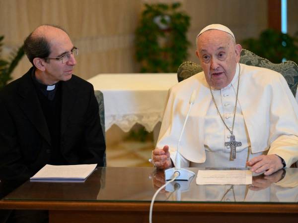 Esta fotografía tomada y publicada por la oficina de prensa del Vaticano el 26 de noviembre de 2023 muestra al Papa Francisco (derecha) recitando el Ángelus flanqueado por Mons. Paolo Braida (izq.) en su residencia del Vaticano.