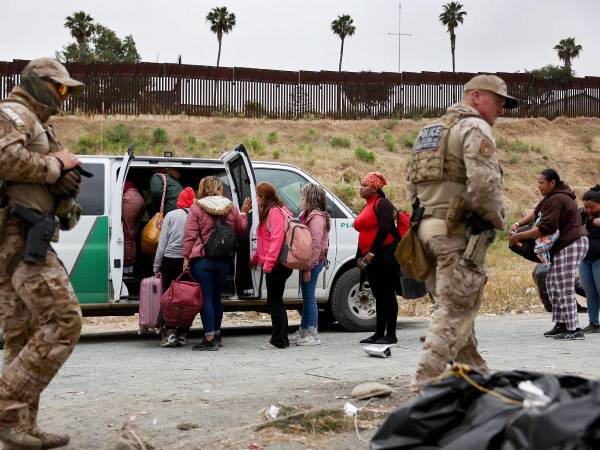 Migrantes abordan un carro de la patrulla fronteriza en Estados Unidos.