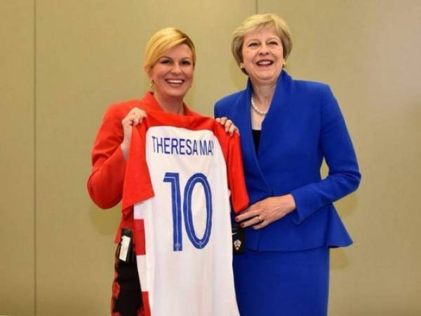 Kolinda, quien ha acaparado la atención por sus sexys fotos en traje de baño, le entrega una camiseta de la Selección de Croacia a la británica Theresa May, cuando ambos países están a punto de enfrentarse en Rusia 2018. (Foto: Twitter)