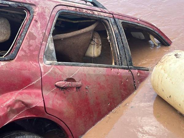 La camioneta Ford roja, con placa HDA 1068, fue encontrada el 27 de agosto sumergida en el río Ulúa. El vehículo presenta múltiples impactos de bala, sugiriendo un ataque armado.