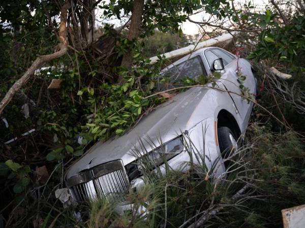 Un Bentley dañado por la tormenta descansa contra un árbol tras el paso del huracán Ian el 1 de octubre de 2022 en Bonita Springs, Florida.