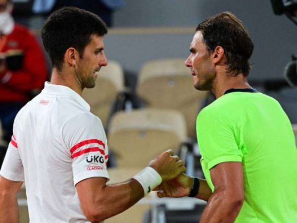 El serbio Novak Djokovic (izq.) Y el español Rafael Nadal se dan la mano al final de la semifinal de tenis masculino individual en el día 13 del torneo de tenis Roland Garros 2021 del Abierto de Francia. Foto:AFP