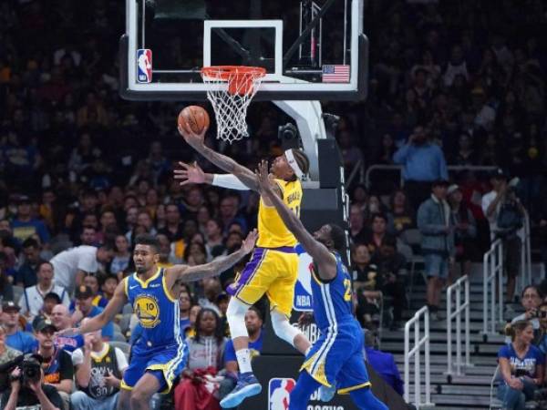 Michael Beasley, el número 11 de los Lakers de Los Ángeles, busca una bandeja sobre Draymond Green, número 23 y Jacob Evans, el número 10 de los Golden State Warriors durante la segunda mitad de su partido de baloncesto de pretemporada de la NBA en el SAP Center el 12 de octubre de 2018 en San José, California. (AFP)