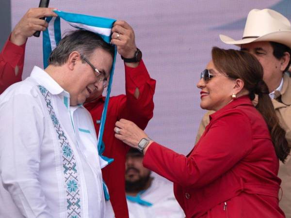 Momento en que la presidenta Castro le ponía la banda del honor al excanciller.